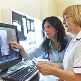 Un médecin et une infirmière examinent une image diagnostique.