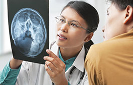 Une médecin examine les résultats d'une IRM avec son patient.