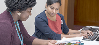 Two women reviewing resources